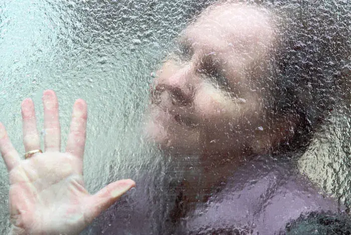 Anciana detrás de vidrio