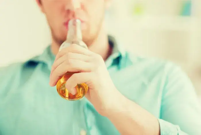 Joven tomando un vaso de cerveza